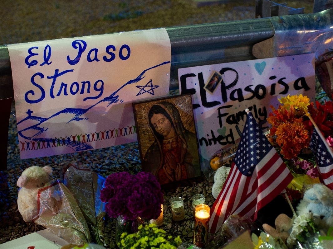 A Virgin Mary painting, flags and flowers adorn a makeshift memorial for the victims of Saturday's mass shooting in El Paso.