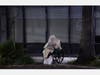 A homeless person sits on a wheelchair under rainy weather on Sunset Blvd., in the Echo Park neighborhood of Los Angeles Monday, April 6, 2020