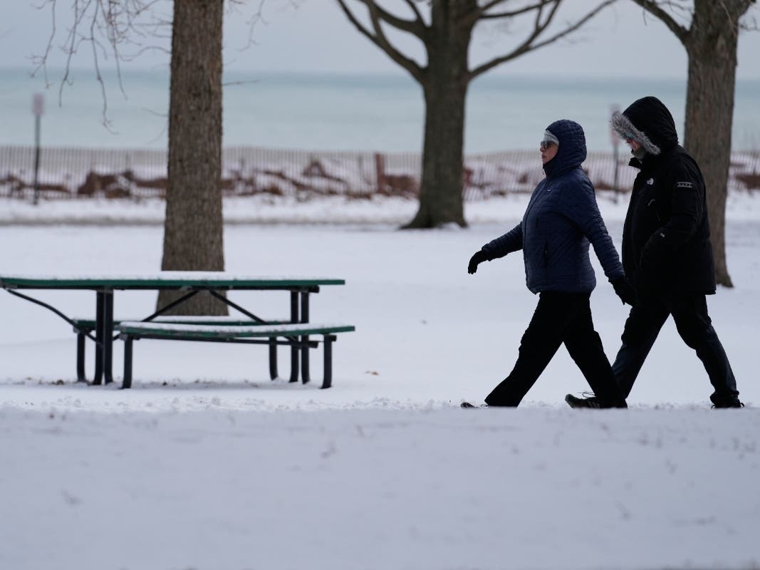 People bundle up as they take a walk Thursday in Evanston. Temperatures are expected to plummet even further Thursday night and Friday.