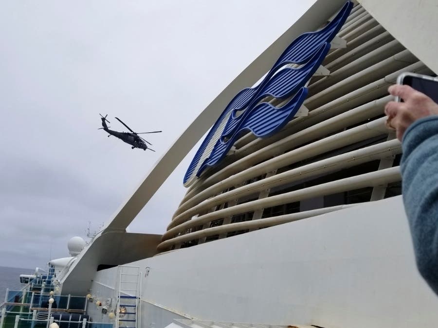  In this photo provided by Michele Smith, a National Guard  helicopter delivering virus testing kits hovers above the Grand Princess cruise ship Thursday, March 5, 2020, off the California coast. 