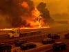 Flames from the LNU Lightning Complex fires jump Interstate 80 in Vacaville, Calif., Wednesday, Aug. 19, 2020. The highway was closed in both directions shortly afterward.