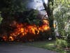A recreational vehicle burns Saturday in Middletown. Two homes were damaged as a result. 