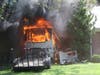 A recreational vehicle burns Saturday in Middletown. Two homes were damaged as a result. 