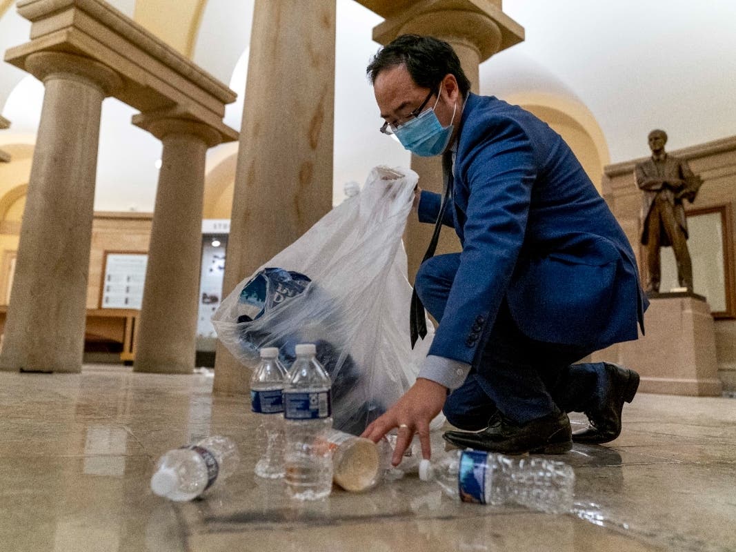 Rep. Andy Kim of New Jersey's 3rd District picks up garbage and debris left on the floor of the Rotunda in the early Thursday after rioters stormed the Capitol on Wednesday.