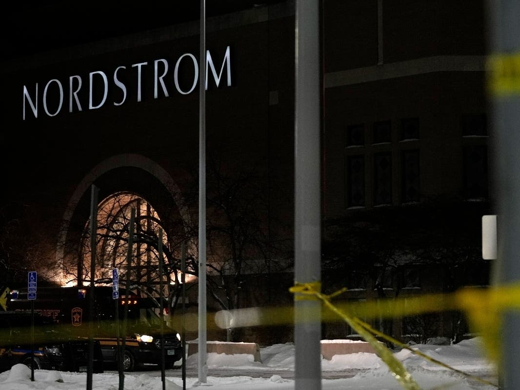 Caution tape and police cars are seen outside Nordstrom at Mall of America after a shooting, Friday, Dec. 23, 2022, in Bloomington, Minnesota. Five people have been arrested in the shooting that killed a 19-year-old man.