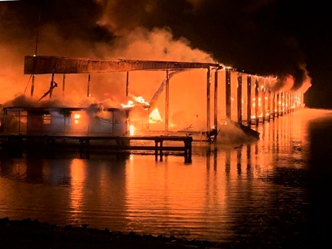 A fire burns on a dock where at least 35 vessels, many of them houseboats, were destroyed by fire early Monday in Scottsboro, Alabama.