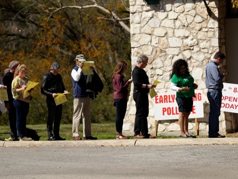 In this Friday, Feb. 28, 2020 photo, voters wait in line at an early polling site in San Antonio.