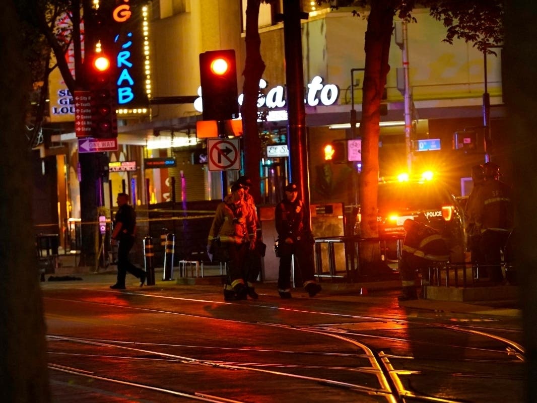 Emergency workers walk in downtown Sacramento, Calif., after a mass shooting Sunday. Six people were killed and 12 others hospitalized.