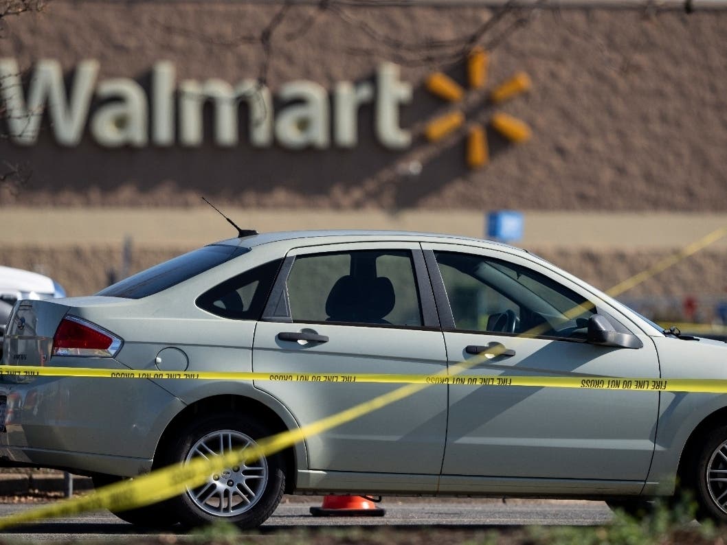 Crime scene tape surrounds a car at the scene of a mass shooting at a Walmart, Wednesday, Nov. 23, 2022, in Chesapeake, Va.
