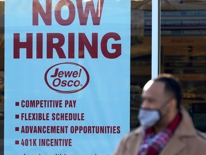 A shopper leaves a grocery store past a hiring sign in Deerfield, Illinois. U.S employers scaled back their hiring amid an acceleration of the pandemic across the country.