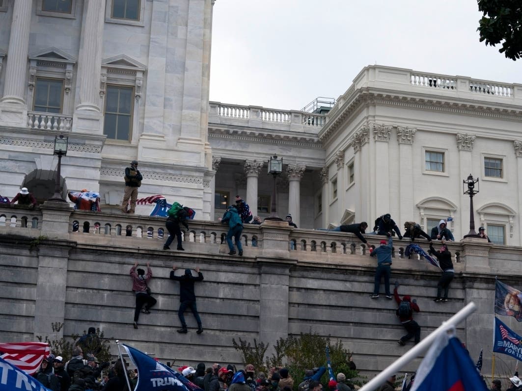 Supporters of President Donald Trump climb the West wall of the the U.S. Capitol on Wednesday, Jan. 6, 2021, in Washington.