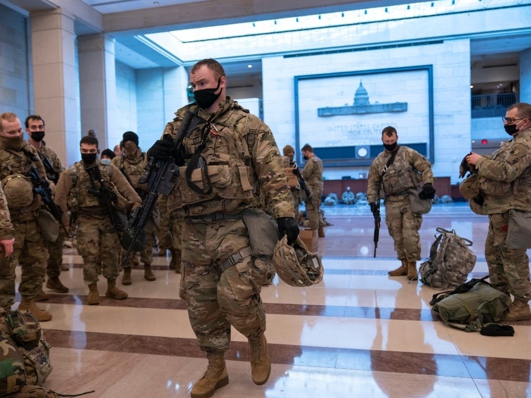 Hundreds of National Guard troops hold inside the Capitol Visitor's Center to reinforce security at the Capitol in Washington, Wednesday, Jan. 13, 2021.