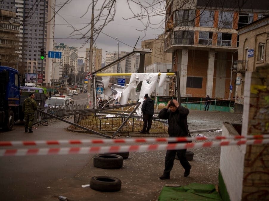 Police officers inspect area after an apparent Russian strike in Kyiv Ukraine, Thursday, Feb. 24, 2022.