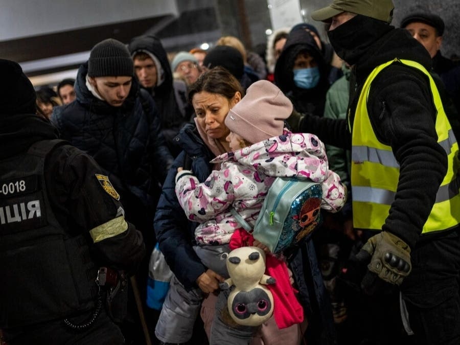 Displaced people line up to get on a train to Poland inside Lviv railway station in western Ukraine on Thursday, March 3, 2022.