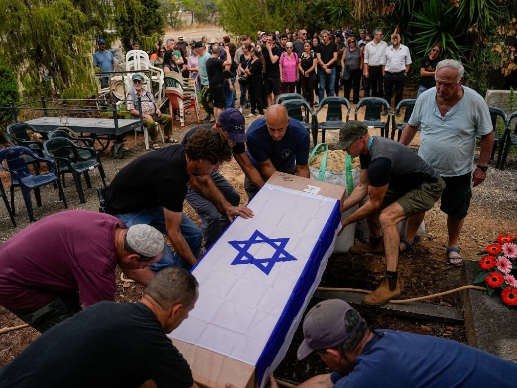 Covered with the Israeli flag, the body of Roi Popplewell is buried at kibbutz Yagur near Haifa, north Israel on Friday, Oct. 27, 2023.