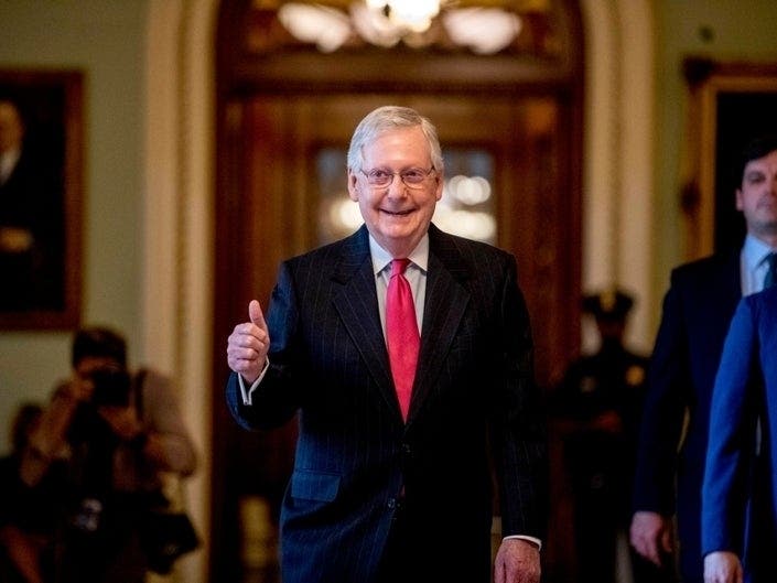 Senate Majority Leader Mitch McConnell of Kentucky gives a thumbs up as he leaves the Senate chamber on Capitol Hill late Wednesday night.
