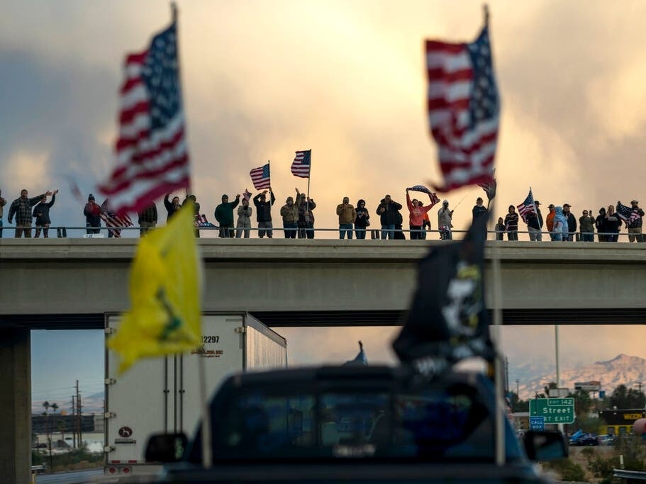 Supporters cheer on a trucker caravan heading toward Washington D.C. to protest COVID-19 mandates last Wednesday in Needles, California.