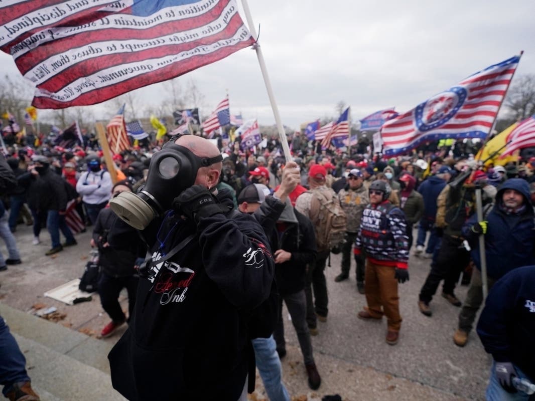 Police with guns drawn watch as protesters try to break into the House Chamber at the U.S. Capitol on Wednesday, Jan. 6, 2021, in Washington. 
