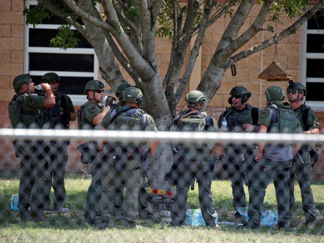 Law enforcement personnel stand outside Robb Elementary School following a shooting, Tuesday, May 24, 2022, in Uvalde, Texas.
