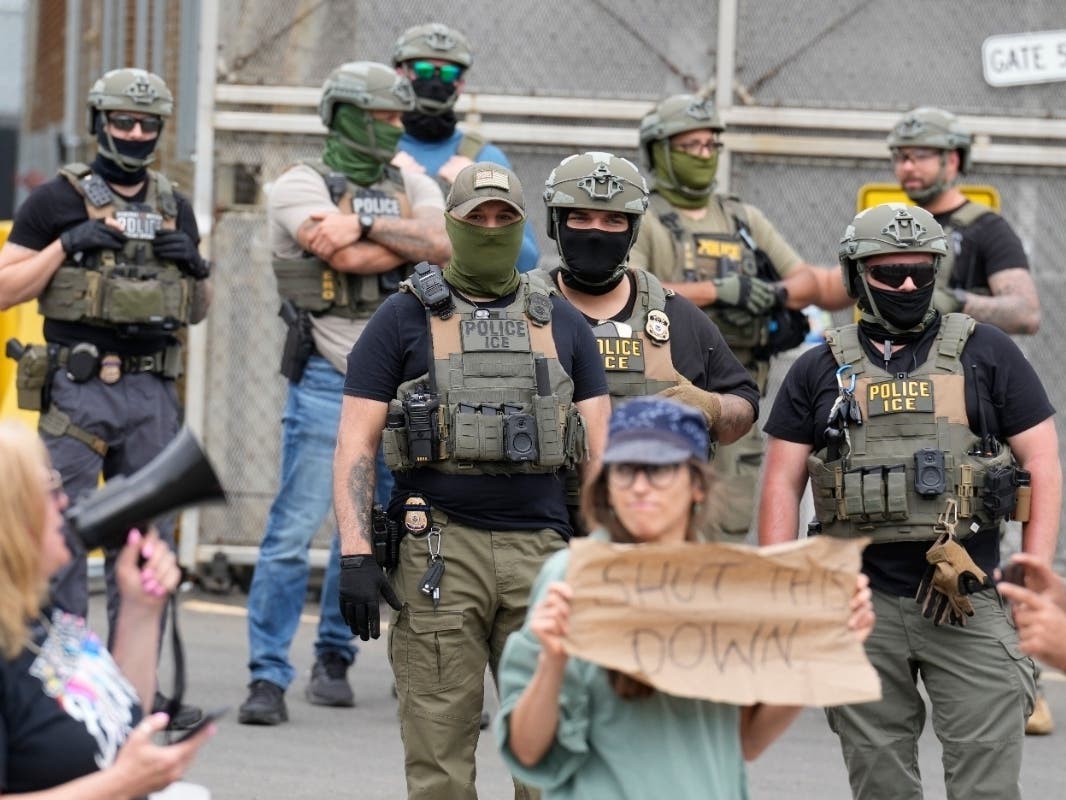 Masked federal agents stand outside the Delaney Hall detention center during a protest against the transfer of detainees on Wednesday, May 27, 2026, in Newark, N.J. (