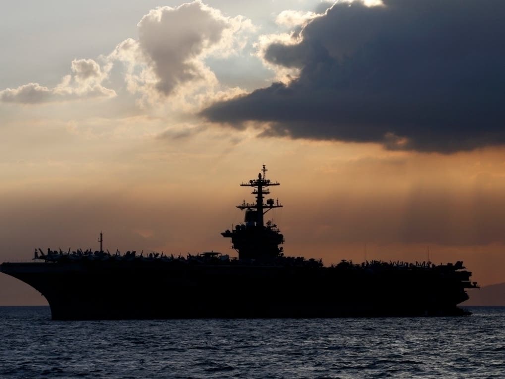 In this April 13, 2018, file photo the USS Theodore Roosevelt aircraft carrier is anchored off Manila Bay west of Manila, Philippines. 