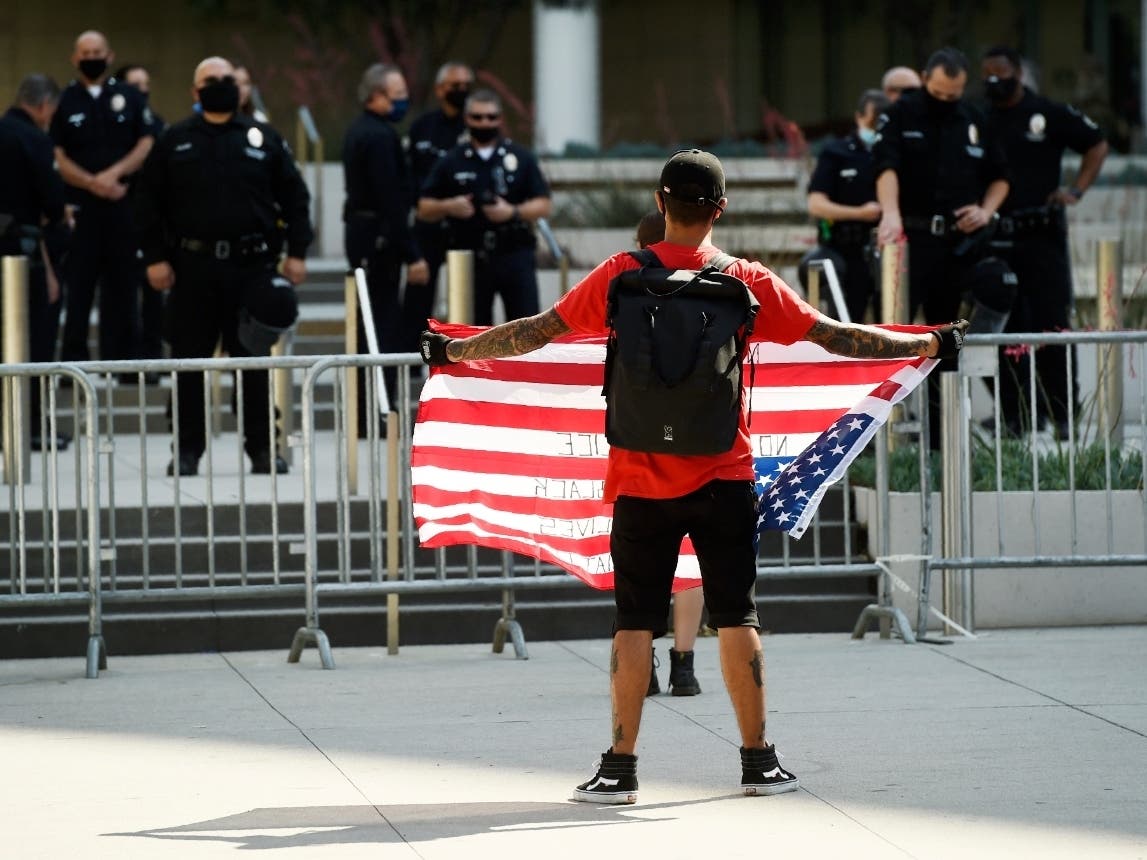 Stephen Chang of Los Angeles protests in front of police officers at Los Angeles Police Department headquarters, Thursday, June 4, 2020, in Los Angeles. 