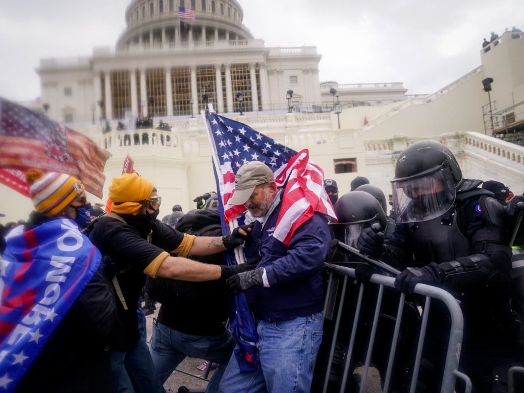 Rioters try to break through a police barrier at the Capitol on Jan. 6, 2021, in Washington.