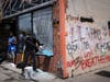 A man cleans up a broken window to a barber shop after shots were fired in George Floyd Square on the one year anniversary of George Floyd's death on Tuesday, May 25, 2021, in Minneapolis. The intersection where George Floyd died was disrupted by gunfire.