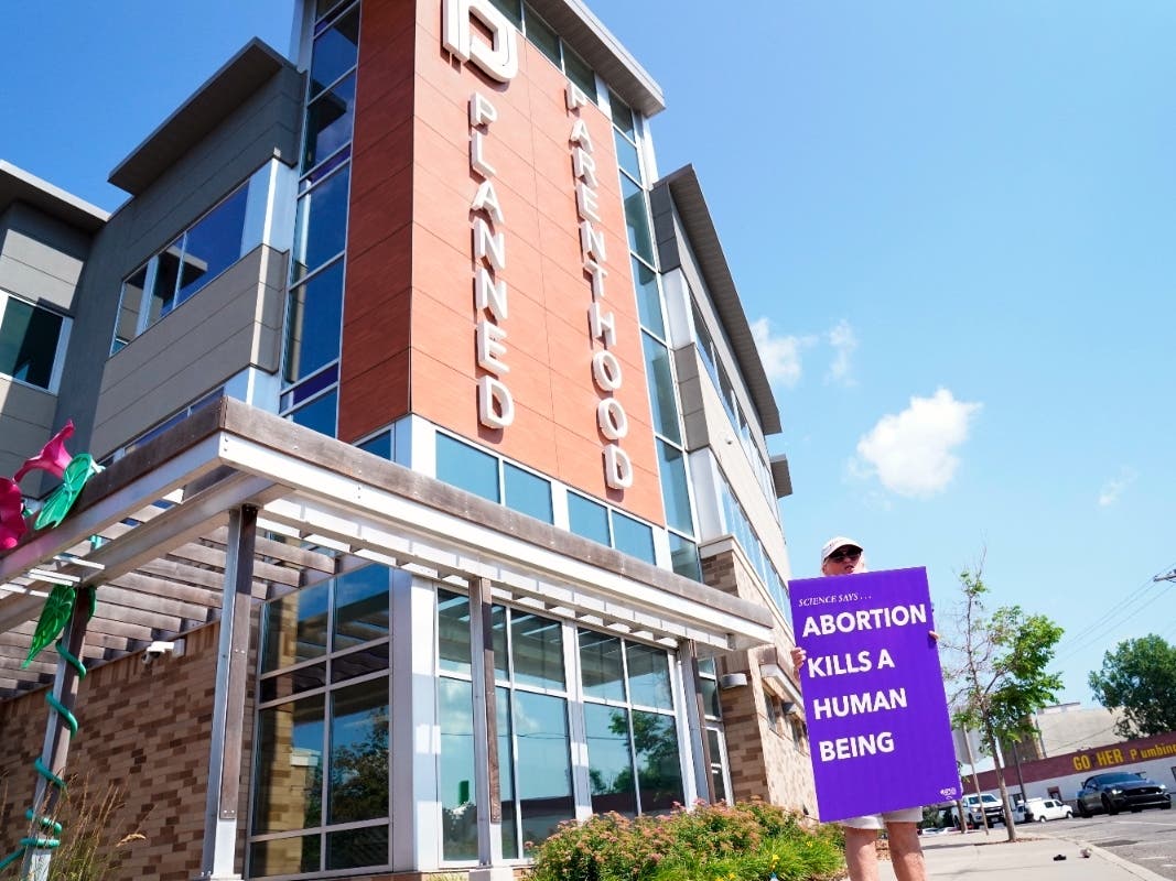 A protester demonstrates in front of a Planned Parenthood, Tuesday, July 12, 2022, in Saint Paul, Minn.