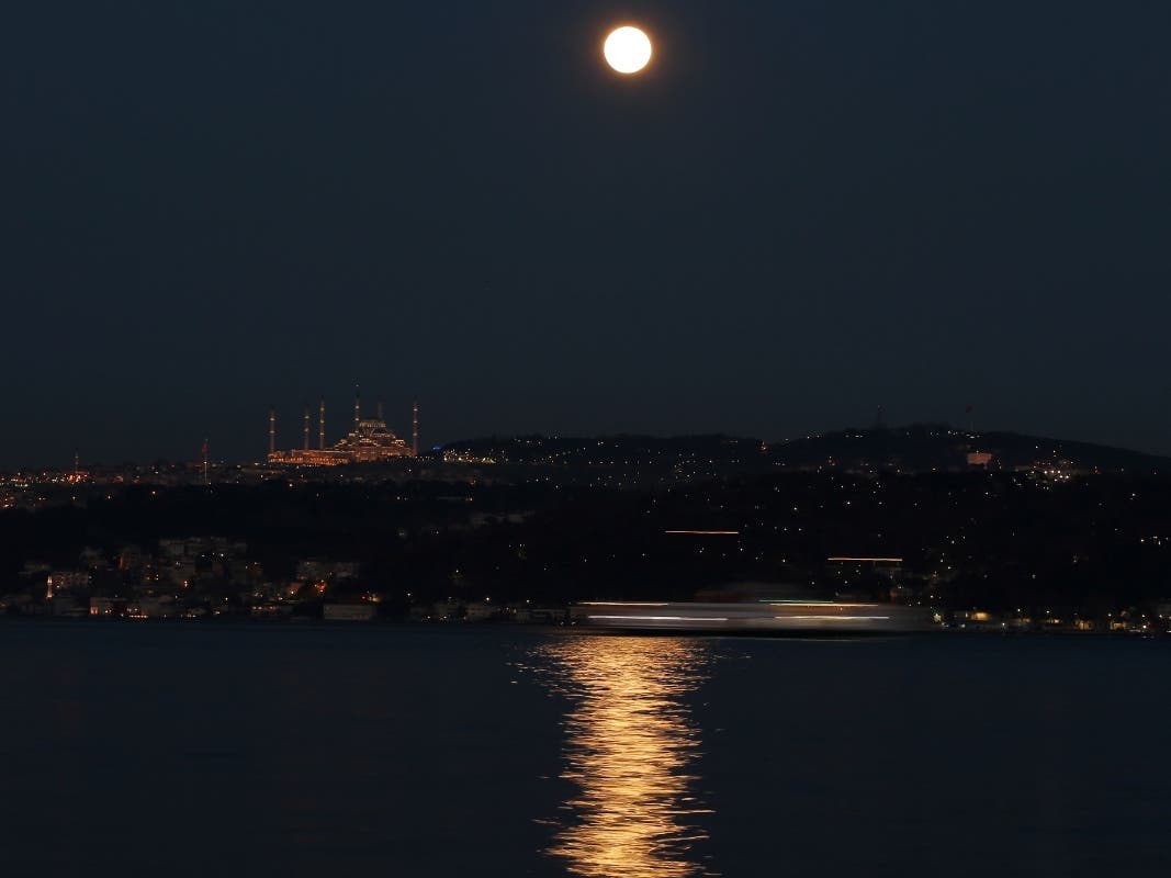 The full moon rising over the sky in Istanbul, Sunday, March 28, 2021 , is reflected on the Bosphorus Strait separating European and Asian sides of the metropolis. The March full moon is called the "Worm Moon."
