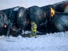 Firefighters work near piled up train cars, near Raymond, Minn., Thursday, March 30, 2023, the morning after a BNSF freight train derailed.