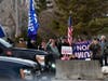 Supporters of former president Donald Trump watch the motorcade with President Joe Biden as he arrives at Cummins Power Generation Facility in Fridley, Minn., Monday, April 3, 2023.