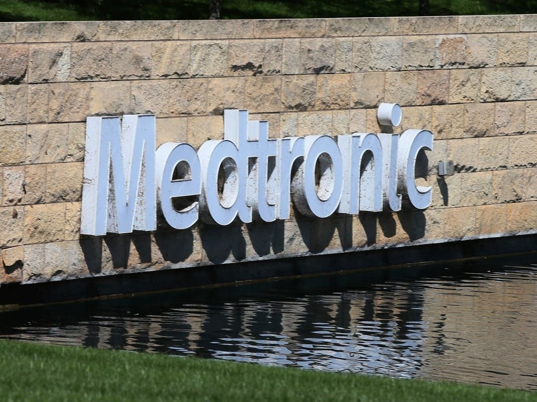 In this Aug. 29, 2019 file photo, the Medronic logo is reflected in a lake at the company's offices in Fridley, Minn.