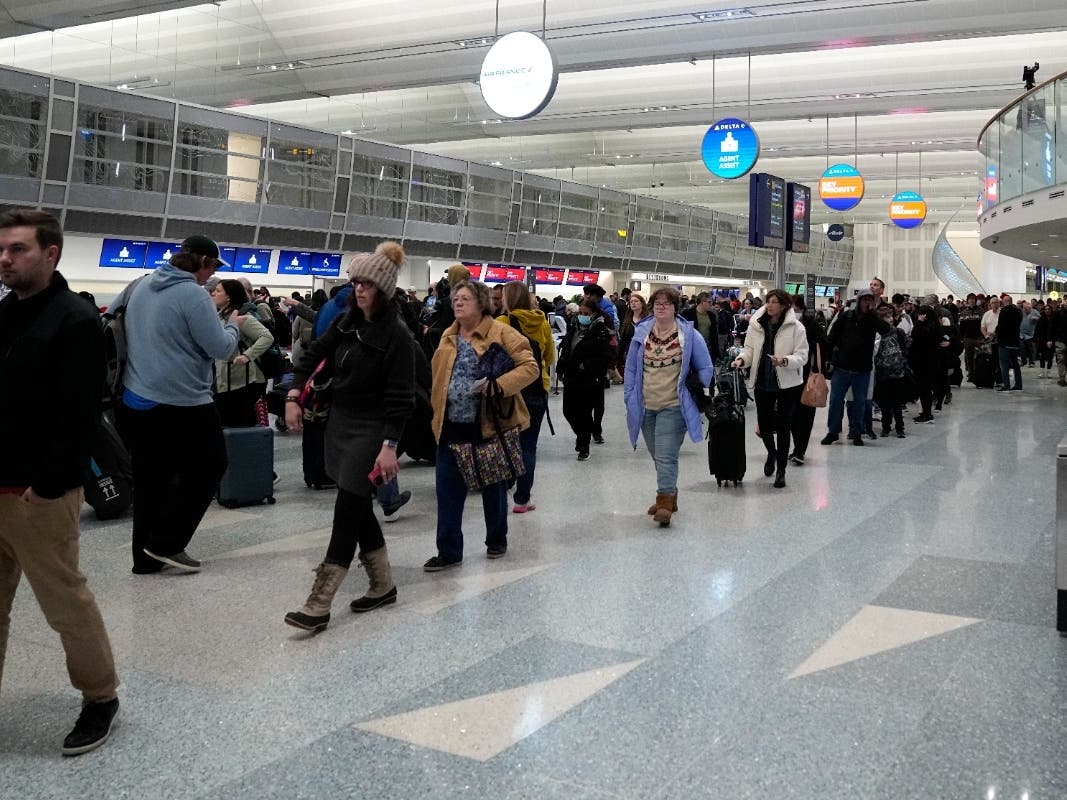 Travelers wait in line to go through security in Terminal 1 at Minneapolis St. Paul Airport, Wednesday, Dec. 21, 2022, in Minneapolis.