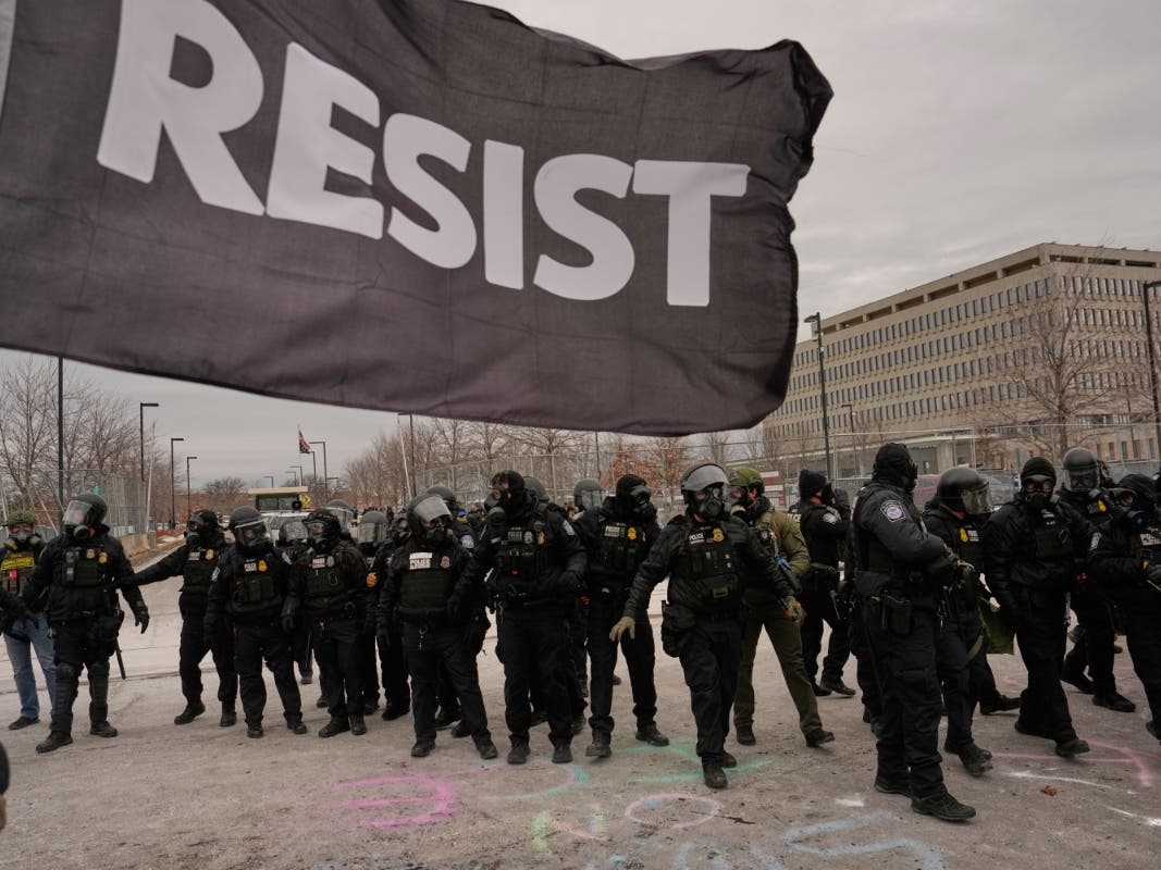 Federal immigration officers confront protesters outside Bishop Henry Whipple Federal Building, Thursday, Jan. 15, 2026, in Minneapolis.