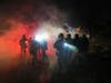 Law enforcement officers stand amid tear gas at the scene of a reported shooting Wednesday, Jan. 14, 2026, in Minneapolis.