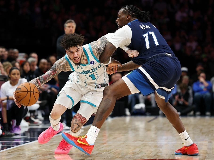 Charlotte Hornets guard LaMelo Ball (1) works around Minnesota Timberwolves center Naz Reid (11) during the second half of an NBA basketball game, Sunday, April 5, 2026, in Minneapolis. 