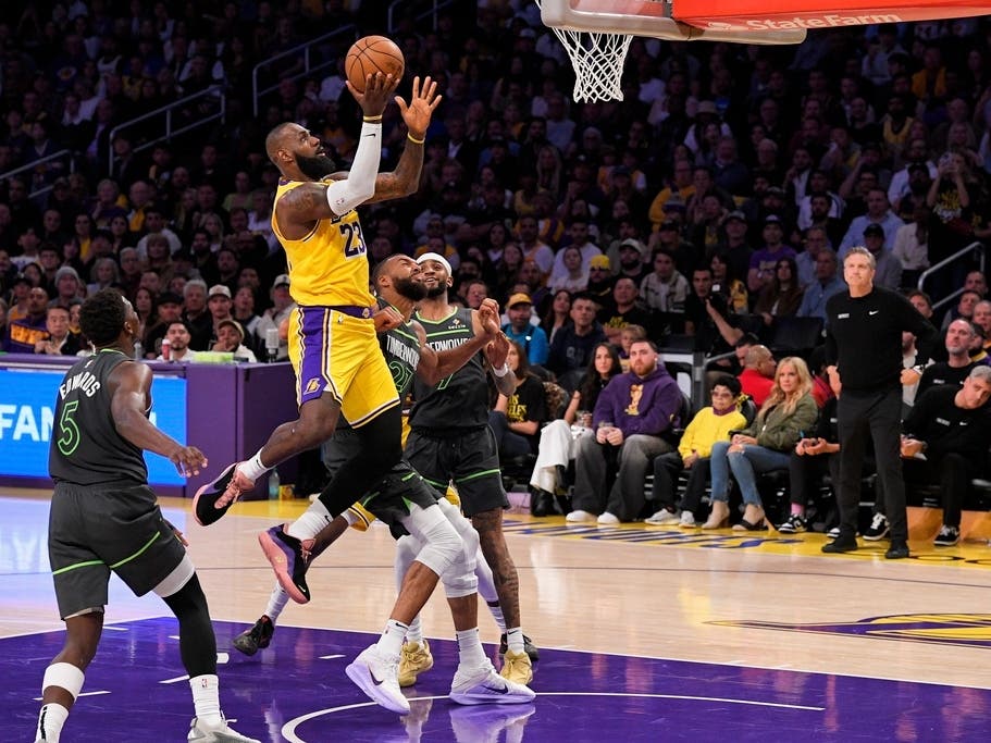 Los Angeles Lakers forward LeBron James (23) shoots as Minnesota Timberwolves guard Anthony Edwards (5), center Rudy Gobert (27) and guard Nickeil Alexander-Walker (9) defend during the second half in Game 5 of an NBA basketball first-round playoff.