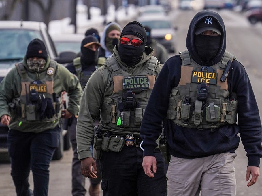 FILE - Federal agents walk down a street while conducting immigration enforcement operations in Minneapolis, Feb. 5, 2026.