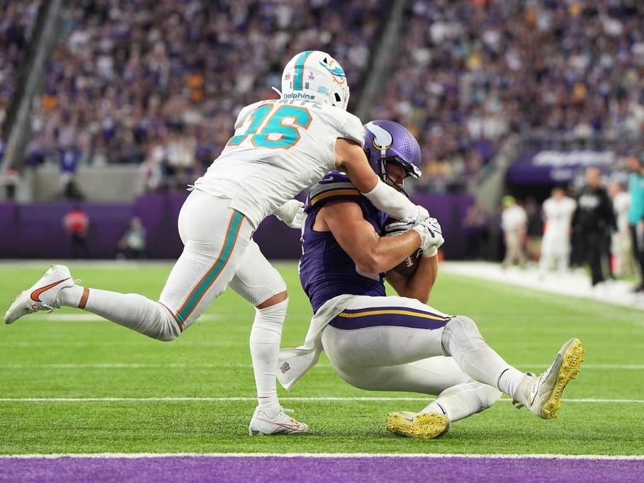 Minnesota Vikings tight end T.J. Hockenson, right, slides to down the ball as Miami Dolphins safety Michael Taaffe (16) tries to stop him during the second half of an NFL football game Sunday, Oct. 4, 2026, in Minneapolis.
