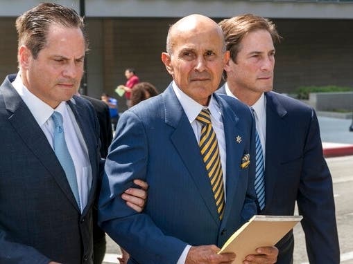 Former Los Angeles County Sheriff Lee Baca, center, walks with attorneys, David Hochman, left, and Nathan Hochman, outside federal court in Los Angeles Friday, May, 12, 2017, after he was sentenced to 3 years in prison for obstructing an FBI investigation
