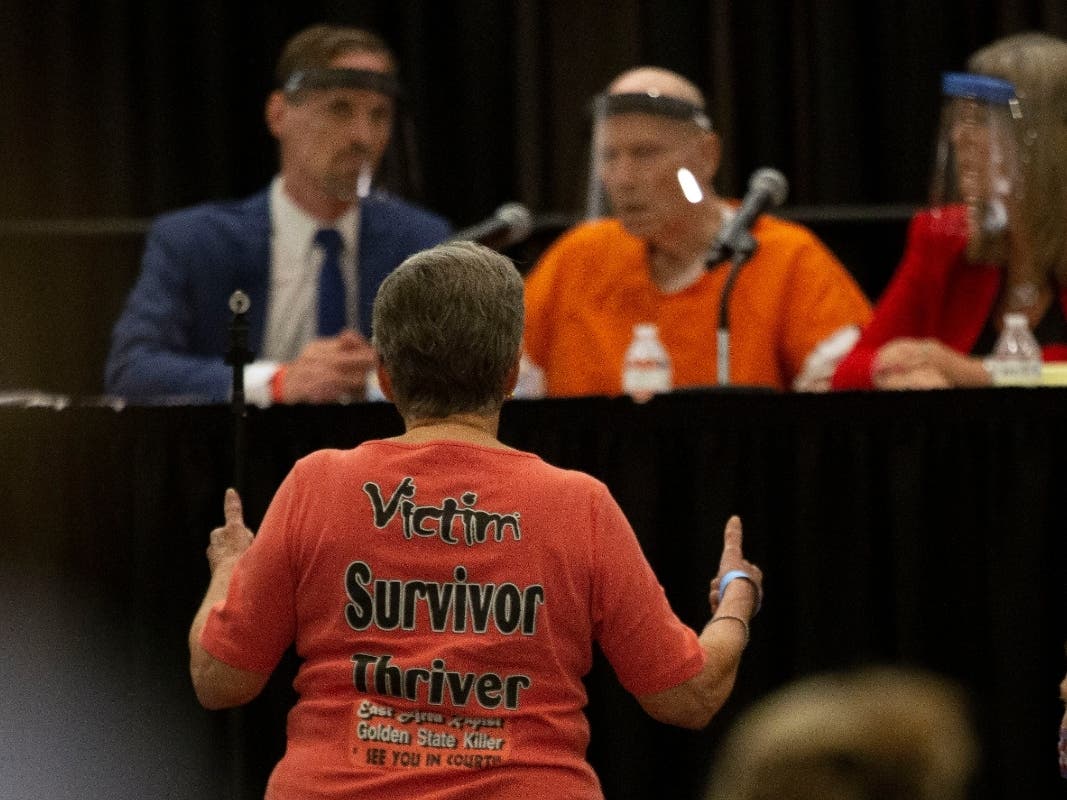 Jane Carson-Sandler, a 1976 rape victim of Golden State Killer Joseph James DeAngelo, stands and gives a double thumbs-up to agree with a prosecutor's statement about part of DeAngelo's anatomy, during a Sacramento court hearing.
