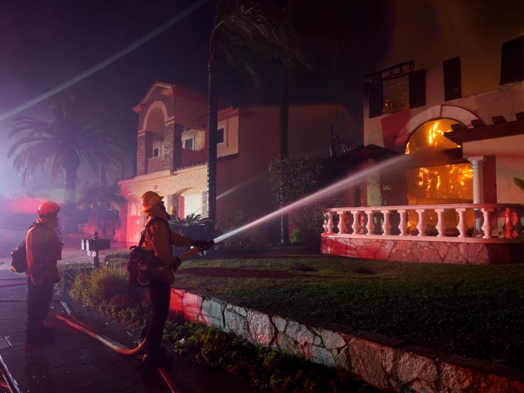 Firefighters work to put out a structure burning during a wildfire Wednesday, May 11, 2022, in Laguna Niguel, Calif. 