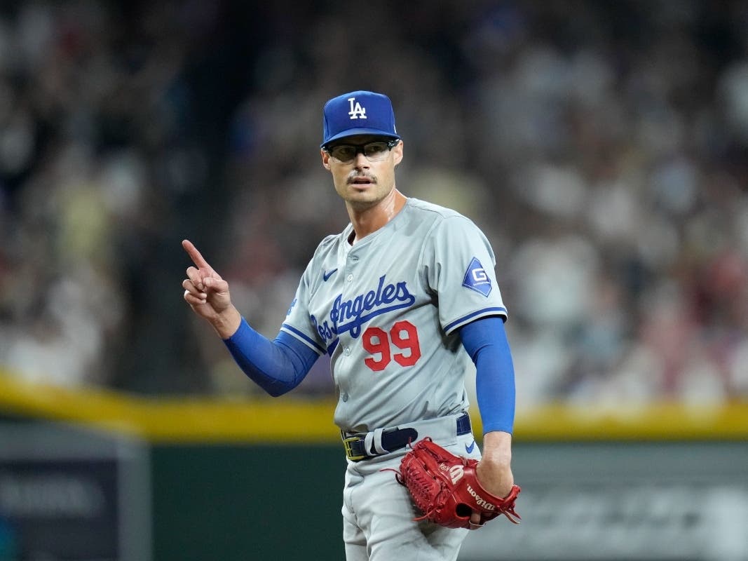 Los Angeles Dodgers relief pitcher Joe Kelly signals to the bench after being called for too many pickoff throws to first base during the third inning of a baseball game against the Arizona Diamondbacks Friday, Aug. 30, 2024, in Phoenix.
