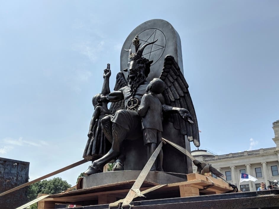 The Satanic Temple unveils its statue of Baphomet, a winged-goat creature, at a rally for the first amendment in Little Rock, Ark., Thursday, Aug. 16, 2018.