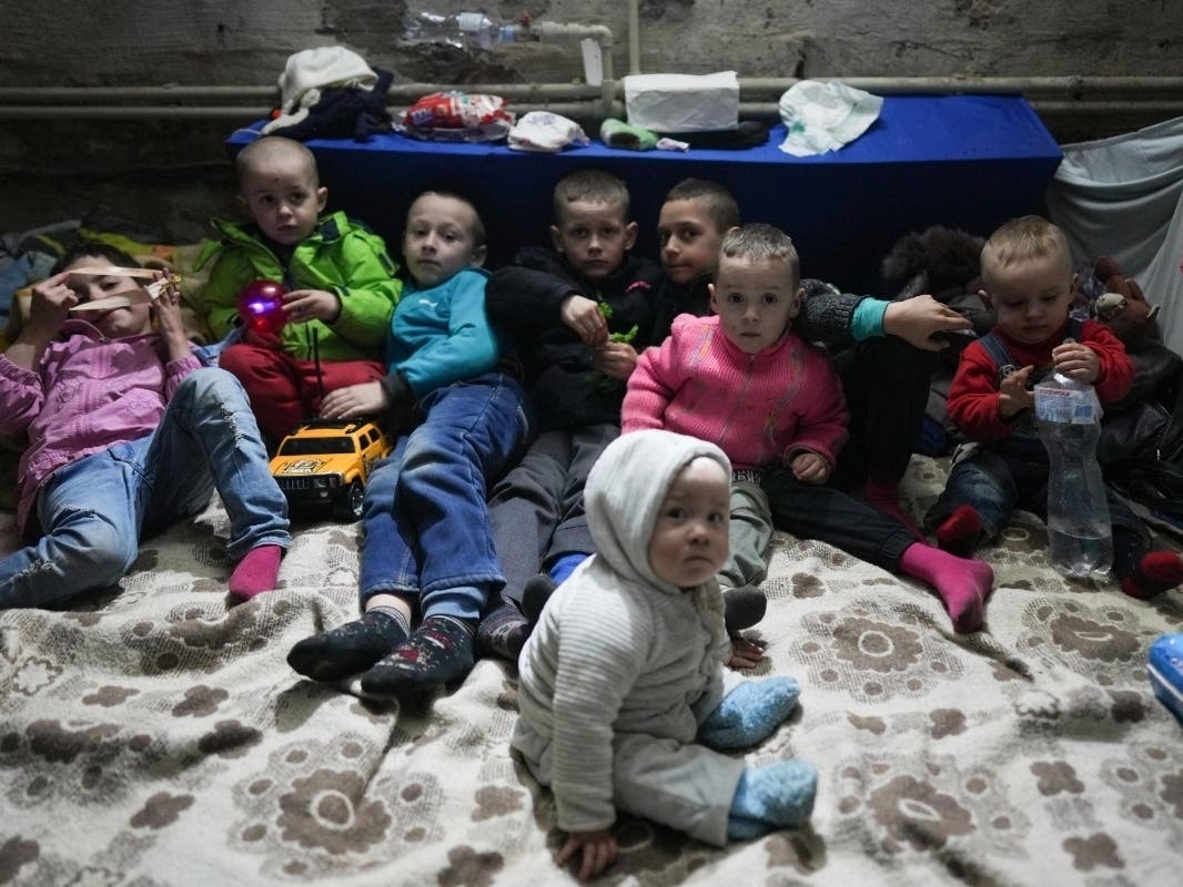 Children pose for a photographer in the bomb shelter in Mariupol, Ukraine, Sunday, March 6, 2022.