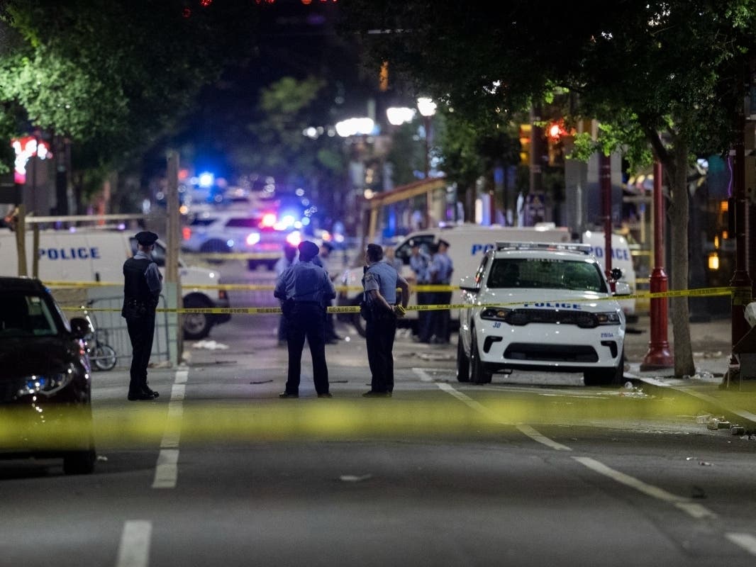 Philadelphia Police officers and detectives look over evidence at the scene of a shooting in Philadelphia, Sunday, June 5, 2022.
