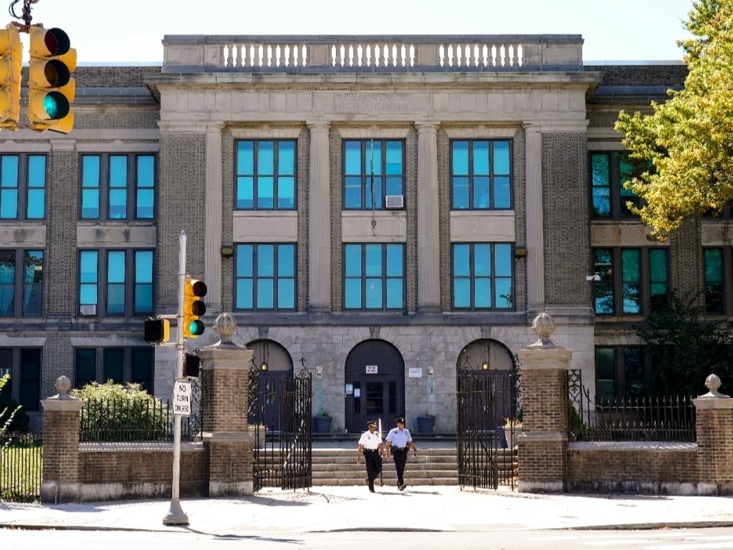 Police officers walk from Roxborough High School near where multiple people were shot in Philadelphia, Wednesday, Sept. 28, 2022.