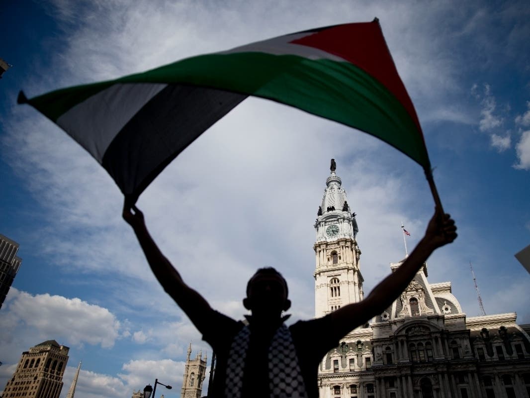 A protester waves a flag as he demonstrate in opposition of the ongoing Israeli military operation on the Gaza strip, in Friday, July 18, 2014, in Philadelphia.
