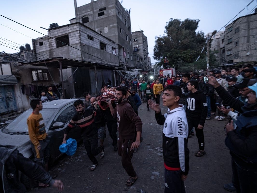 Palestinians carry a body from a site of an Israeli airstrike, in Rafah, Gaza Strip, Tuesday, Dec. 12, 2023.
